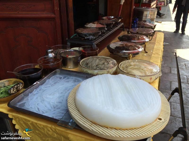 اون دایره سفید رنگ نودل برنج هست که با استفاده از یک رنده رشته ها ازش جدا میشه