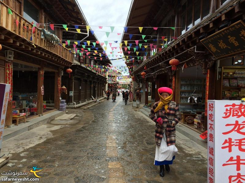  مرکز شهر شانگری لا - سردی هوای اول اردیبهشت از لباس های این خانم تبتی آشکار است