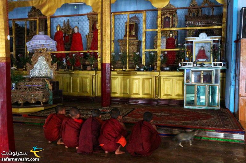 مانک ها در حال خواندن دعا در مقابل بودا